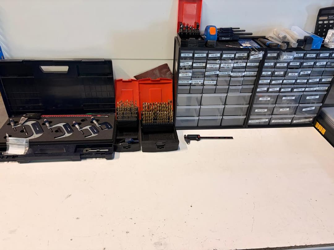 Établi d'atelier d'usinage aluminium organisé avec micromètres, forets et outils de mesure